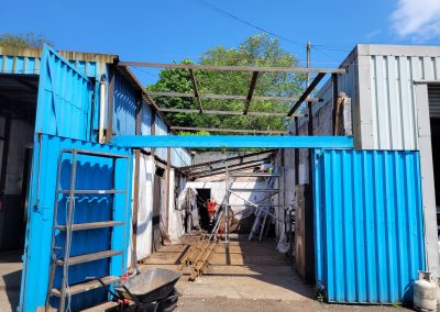 "Partially constructed garage with scaffolding and metal beams in place.