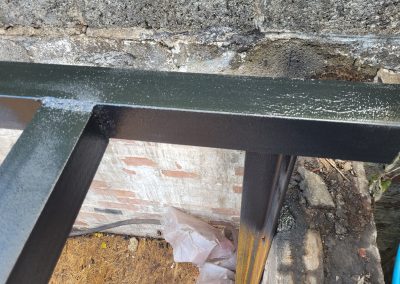 Close-up of a metal frame beam with a smooth, painted finish during construction.
