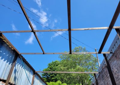 Metal frame structure under a blue sky during the construction phase of the garage.