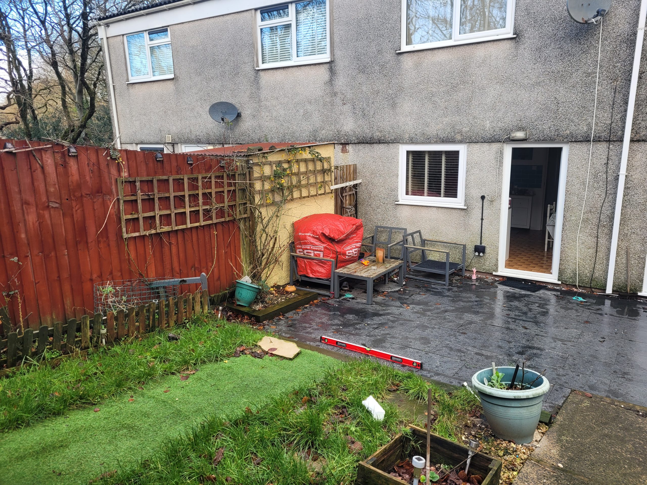 Before – Outdoor Space Prior to Pergola Build Garden area before pergola installation, showing plain patio and outdoor seating